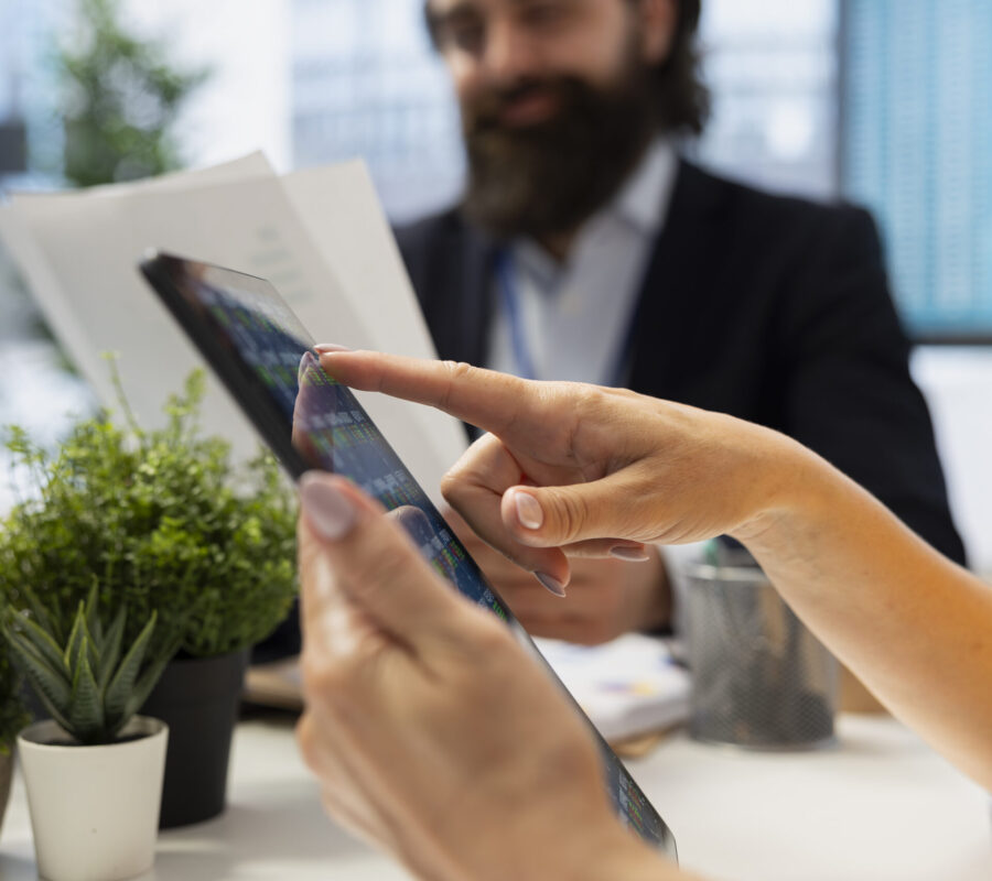 Agent offering advice on buying and selling stocks on tablet online, close up Financial advisor guiding clients in trading shares using software on tablet, making informed investment decisions. Agent offering advice on buying and selling stocks on device online, close up